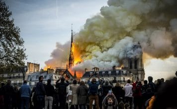 People watch the landmark cathedral burning in central Paris