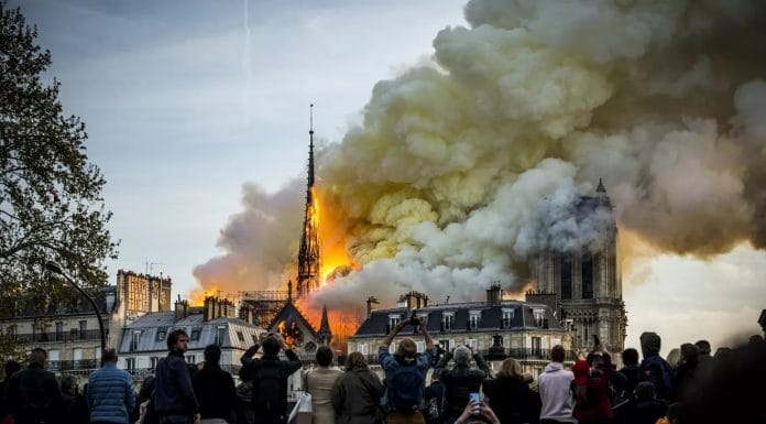 People watch the landmark cathedral burning in central Paris