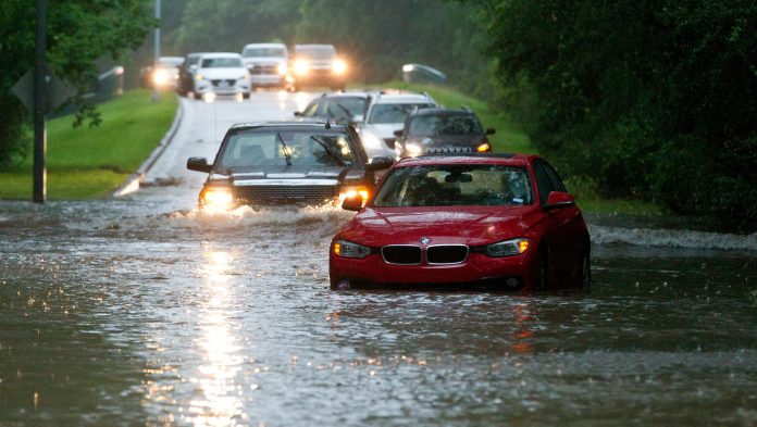 Vehicles wade through flooded Kingwood Drive as deadly thunderstorms hit the Kingwood area Tuesday, May 7, 2019, in Texas.