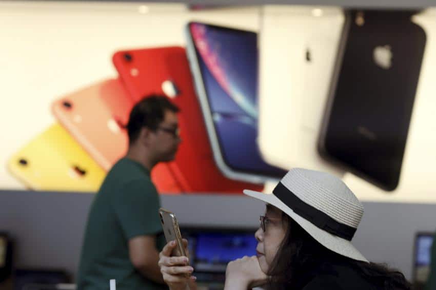 A customer looks at her iPhone in a store of U.S. tech company Apple in Beijing on Friday.