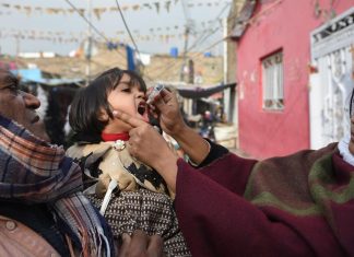 A Pakistani health worker administers polio vaccine drops to a child during a polio vaccination campaign in Islamabad on December 12, 2018.