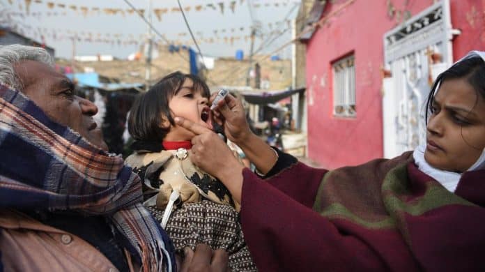 A Pakistani health worker administers polio vaccine drops to a child during a polio vaccination campaign in Islamabad on December 12, 2018.