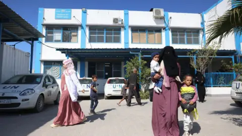 AFP Palestinians walk outside an Unrwa medical centre in Khan Younis, in the southern Gaza Strip (29 October 2024)