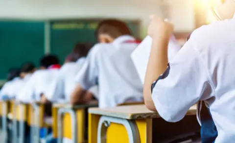 Getty Images Rear view of middle school students studying in classroom.