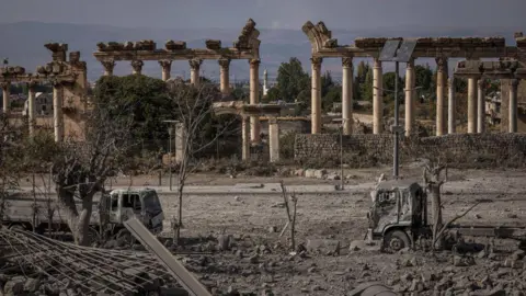 Getty Images Rubble and a burnt-out truck in the site next to Roman ruins hit by an IDF bomb on 6 November