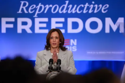 Getty Images Kamala Harris stood in front of a 'Reproductive FREEDOM' sign