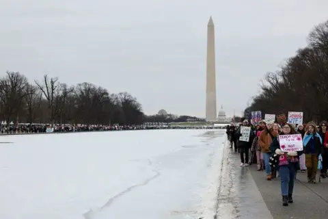 Getty Images Protesters walk along the National Mall near the Washington Monument