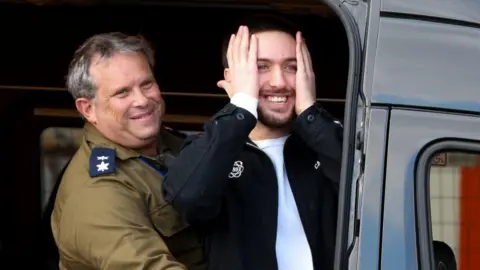 Reuters Image shows Omer Shem Tov holding his hands to his face and smiling after he was released as part of a hostages-prisoners swap and a ceasefire deal between Hamas and Israel, at Beilinson Schneider complex in Petah Tikva, Israel, on 22 February, 2025